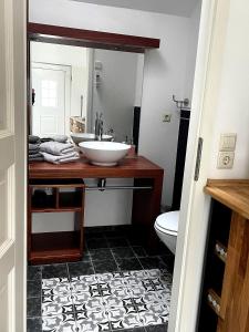 a bathroom with a sink and a mirror at FEWO im Kneipenviertel Altkötzschenbroda in Radebeul +12 photos