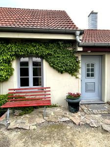 拉德博伊爾的住宿－FEWO im Kneipenviertel Altkötzschenbroda，坐在房子前面的红色长凳