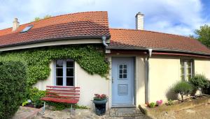 a house with a red roof and a red bench at FEWO im Kneipenviertel Altkötzschenbroda in Radebeul
