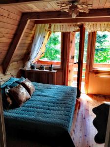 a bedroom with a blue bed in a log cabin at Gierkówka - Górska Rezydencja Pierwszego Sekretarza in Zwardoń