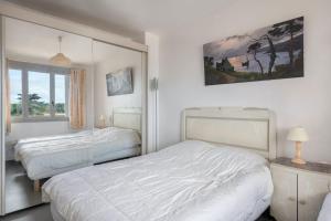 biała sypialnia z 2 łóżkami i oknem w obiekcie Situation ideale a Pornichet w mieście Pornichet