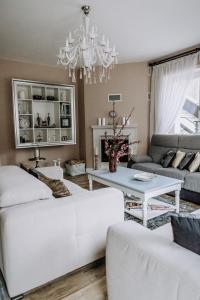 a living room with white furniture and a chandelier at Willa Sepia SPA in Wisła