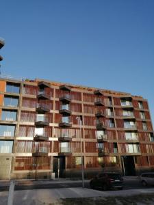 un immeuble d'appartements avec des voitures garées devant lui dans l'établissement Apartment PURO HOMES, à Aveiro