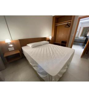 una camera da letto con un letto con un piumone bianco di Salinas Exclusive Resort Apartamento 2 quartos a Salinópolis