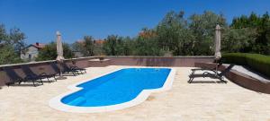 a swimming pool on a patio with chairs at Little Dream in Poljana