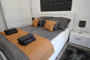 a bed with two pillows on it in a room at True Gem at the Airport by NW Apartments in Budapest