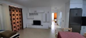 a living room with a couch and a television at Apartment Suite Family in Shëngjin