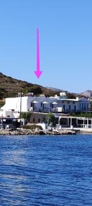 a large white building next to a body of water at Afrodite Luxury Rooms in Kalymnos