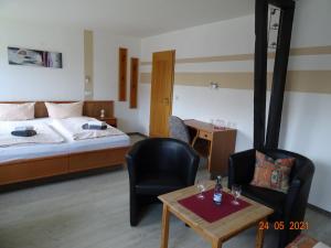 Habitación de hotel con cama, mesa y sillas en Pension Müritzblick, en Gotthun