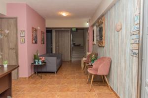 a waiting room with pink walls and chairs at Villa Rafailia in Olympiaki Akti