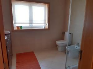 ein kleines Badezimmer mit Toilette und Fenster in der Unterkunft Vivenda do Parque Arouca in Arouca + 13 Fotos