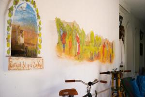 a wall with paintings and a bike on it at Casa de Coria in Chacras de Coria