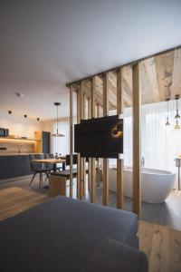 uma sala de estar com uma banheira e uma cozinha em Schuischta Mountain Apartments em Sesto