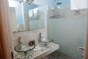 y baño con ducha y 2 lavabos de cristal. en Calamarina Centro, en Palermo