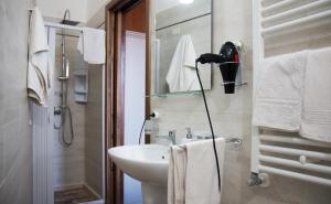 a white bathroom with a sink and a shower at La Teresa B&B in Copertino