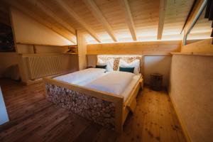 Cama grande en habitación con suelo de madera en Chalet Passeier - ZOLL, en Saltusio