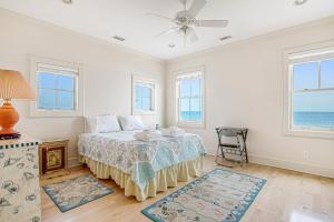 um quarto com uma cama e uma ventoinha de tecto em Blue Waters Beachfront em Folly Beach