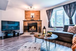 a living room with a couch and a fireplace at Townhouse On The Golf W Pool Access -aiglon 1717 in Mont-Tremblant