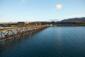 a train crossing a bridge over a body of water at The Singular Patagonia Hotel in Puerto Natales