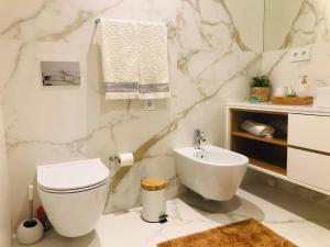 Apartment PURO HOMES في أفيرو: حمام ابيض مع مرحاض ومغسلة