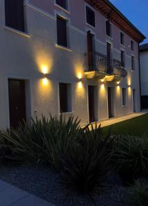 a white building with lights on the side of it at Villa Giotto Luxury Suite & Apartments in Mestre