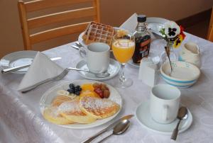 a table with a plate of pastries and orange juice at Coill an Rois B&B in Ballydavid