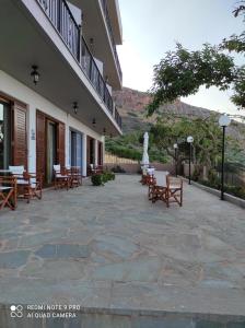 eine Terrasse mit Tischen und Stühlen vor einem Gebäude in der Unterkunft Castro Hotel in Monemvasia