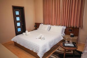 - une chambre avec un lit doté de draps blancs et une fenêtre dans l'établissement Vila 3 Korçë, à Korçë