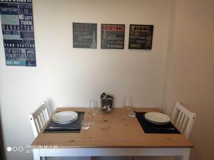 a wooden table with plates and wine glasses on it at Residenza Marvasi 10 in Caserta +2 photos