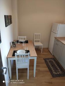 a kitchen with a table and two chairs and a refrigerator at Residenza Marvasi 10 in Caserta