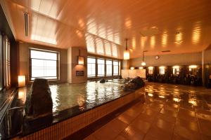 Una piscina de agua en una habitación grande con en Dormy Inn Asahikawa, en Asahikawa