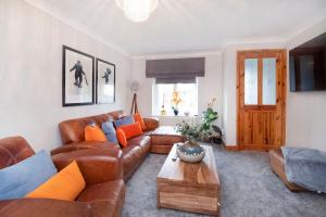 sala de estar con sofá de cuero marrón y mesa en Victoria Retreat en York