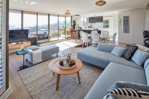 a living room with a blue couch and a table at Inner City Harbour Views With Parking in Sydney