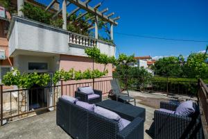 a patio with chairs and a balcony with a building at Oliva in Vrbnik