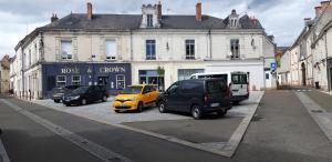 una strada con auto parcheggiate di fronte a un edificio di À 200m du Château 30 min du Circuit du Mans a Le Lude