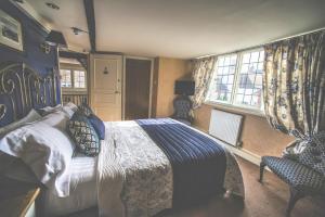 a bedroom with a bed and a chair and a window at Jeakes House in Rye
