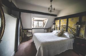 a bedroom with a large bed and a mirror at Jeakes House in Rye