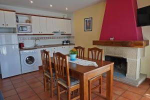 Casa El Puente في بيسييت: مطبخ وغرفة طعام مع طاولة ومدفأة