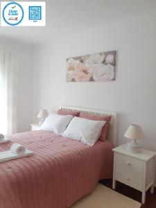a bedroom with a bed with a pink blanket and white pillows at Lousã's Brown & White in Lousã