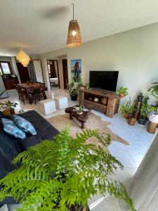 a living room with a couch and a flat screen tv at Casa Pipa Charme do Amor in Pipa