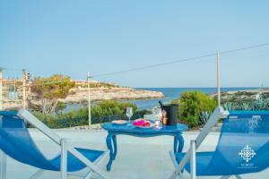 una mesa y sillas en un patio con vistas al océano en Residenza Ormos - Dimore sul mare en Lampedusa