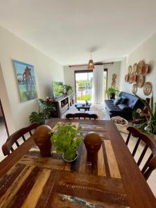 a living room with a wooden table and a couch at Casa Pipa Charme do Amor in Pipa