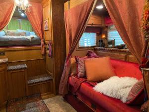 a red couch sitting in a train room at The Pony Experience; Glamping with Private Petting Zoo in Temecula