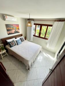 um quarto com uma cama grande num quarto com janelas em Casa Pipa Charme do Amor em Pipa