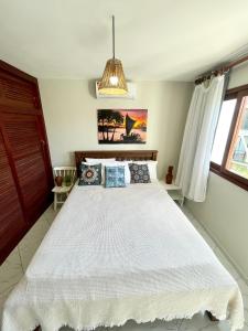 a bedroom with a large white bed in a room at Casa Pipa Charme do Amor in Pipa
