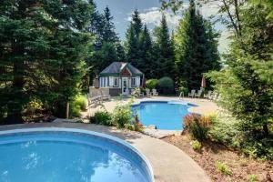 - une piscine dans une cour avec un kiosque dans l'établissement Townhouse On The Golf W Pool Access -aiglon 1748, à Mont-Tremblant