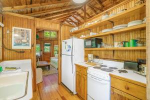 Il comprend une cuisine avec un réfrigérateur blanc et des murs en bois. dans l'établissement Park Vogel Cottage, à Frankfort