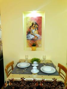 a dining room table with a painting on the wall at Apartment Набережная Иртыша им.Славского in Ustʼ-Kamenogorsk