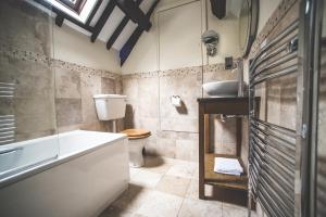 a bathroom with a tub and a toilet and a sink at Jeakes House in Rye