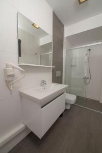 a white bathroom with a sink and a toilet at Mert Otel in Cesme